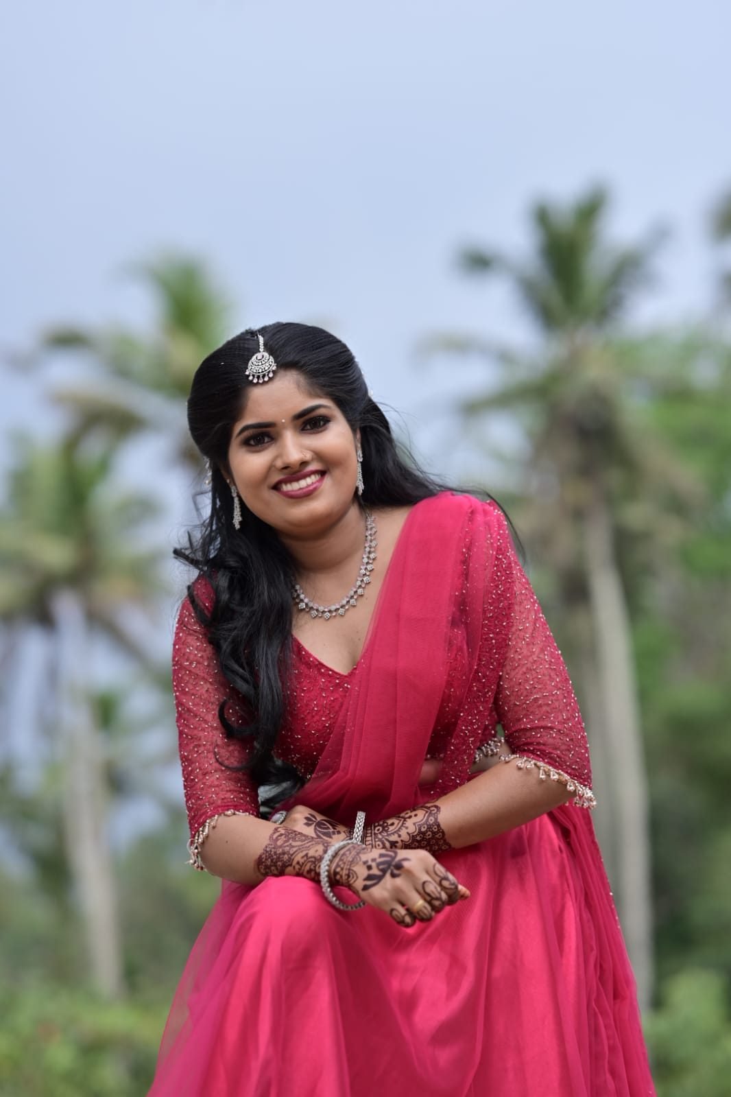 Bridal client smiling in pink outfit with silver jewellery