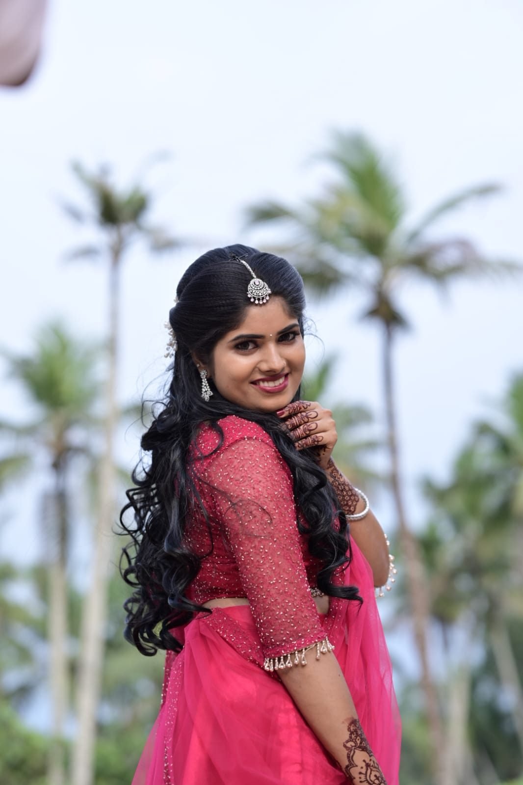 Bridal look in pink outfit with curled hairstyle